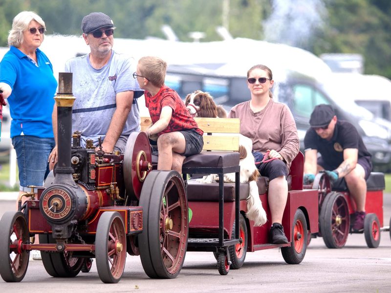 Nellie leading a convoy of miniature engines, with passengers and a springer spaniel riding on her trailer